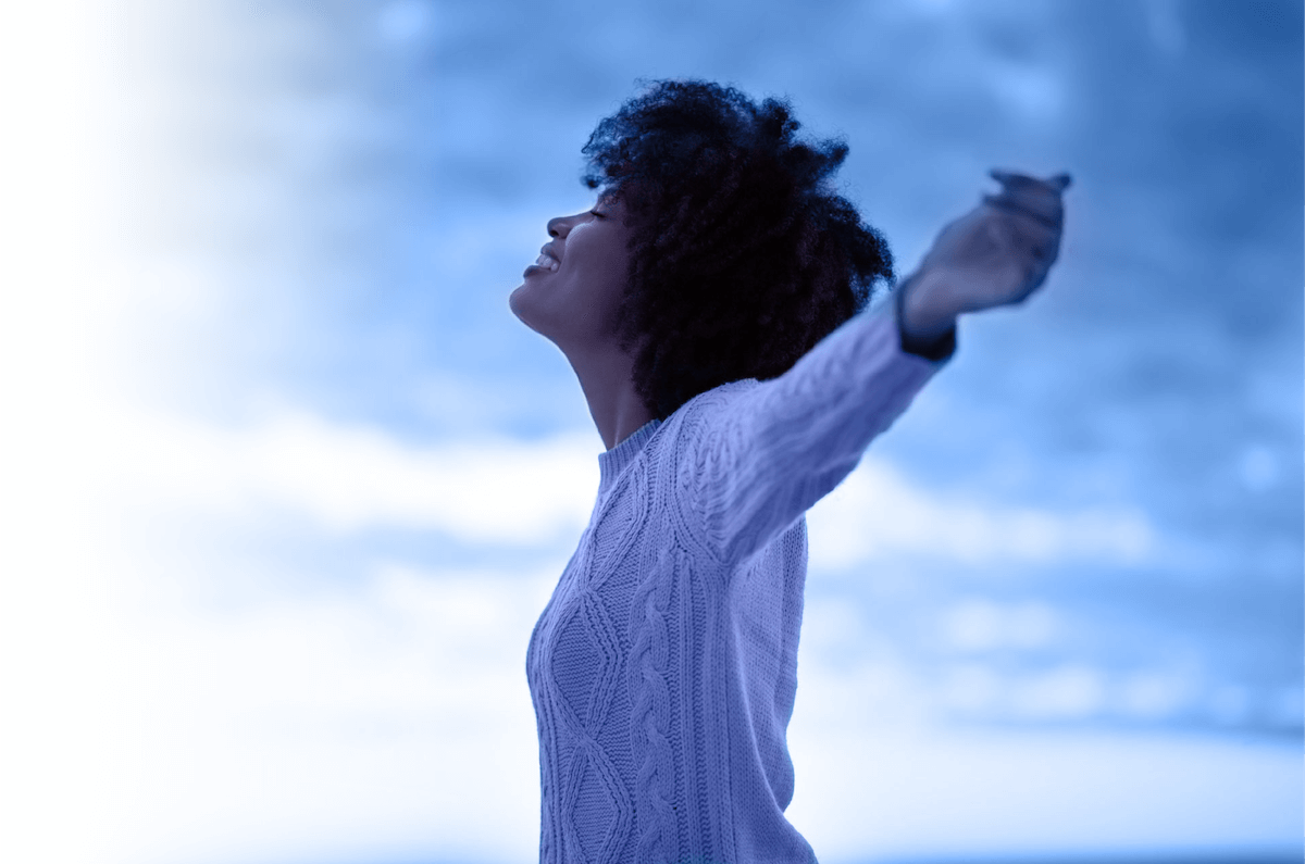 Liberated woman stands with outstretched arms expressing liberation felt from Centre for Holding Space